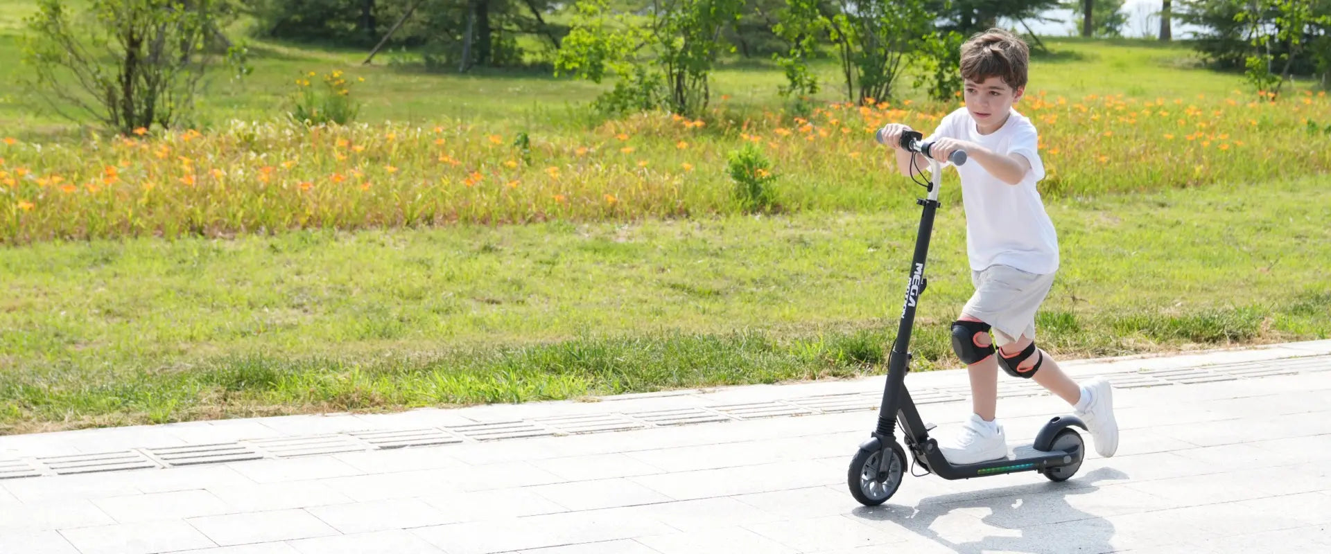 MEGA MOTION ME1 radiant edition children's electric scooter desktop setup. Vibrant cyberpunk LED light effects, punchy 150W motor, 3-speed gear controls at 8-12-16km/h, and hand brake safety system.