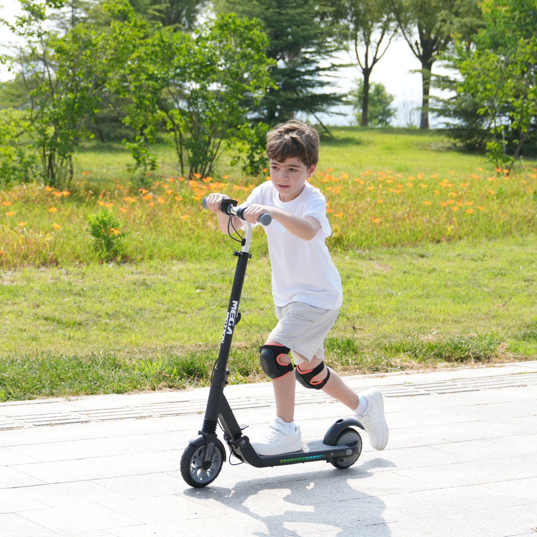 Image of a boy riding a black MEGA MOTION ME1 electric scooter